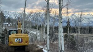 Excavator with snow covered peaks in the background